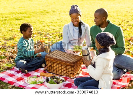 Young smiling family doing a picnic on an autumns day