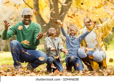 Young smiling family throwing leaves around on an autumns day - Powered by Shutterstock