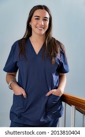 Young Smiling Young Female Doctor Dentist In Dark Blue Uniform Standing In Hallway