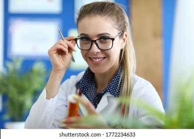 Young Smiling Female Doctor Holds Medicine In Her Hand. New Drug Development