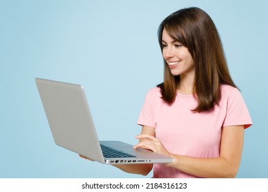 Young Smiling Freelancer Happy Caucasian Woman 20s Wearing Pink T-shirt Hold Use Work On Laptop Pc Computer Isolated On Pastel Plain Light Blue Background Studio Portrait. People Lifestyle Concept.