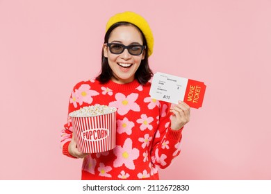 Young smiling fun cool woman of Asian ethnicity in 3d glasses watch movie film hold bucket of popcorn ticket isolated on yellow background studio portrait. People emotions in cinema lifestyle concept