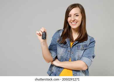 Young Smiling Fun Happy Caucasian Woman 20s In Casual Trendy Denim Jacket Yellow T-shirt Holding In Hand Car Key Fob Keyless System Isolated On Grey Color Background Studio. People Lifestyle Concept