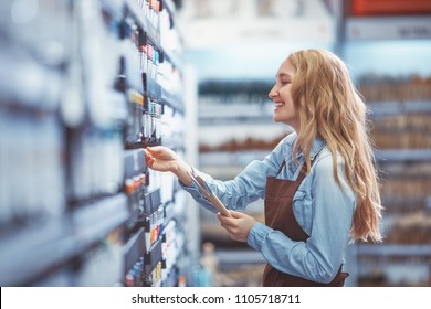 Young Smiling Girl Choosing Paint In Store