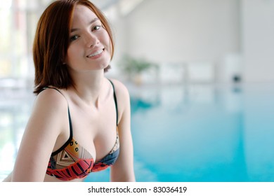 Young smiling girl at the swimming pool (with copy space)