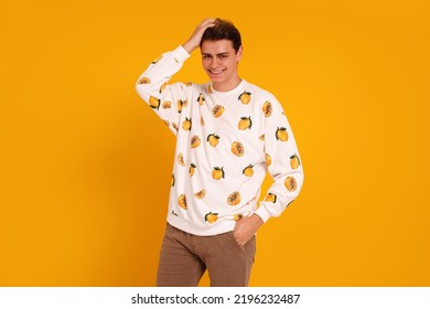 Young Smiling Handsome Man In Fashionable Clothes Posing Isolated On Yellow Studio Background, Looking At The Camera. Real People Emotions And Lifestyle Concept. Copy Space.
