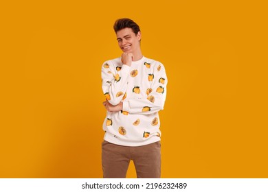 Young Smiling Handsome Man In Fashionable Clothes Posing Isolated On Yellow Studio Background, Looking At The Camera. Real People Emotions And Lifestyle Concept. Copy Space.
