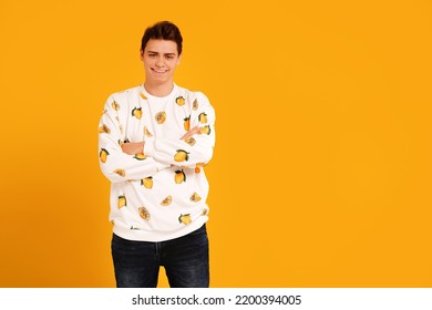 Young Smiling Handsome Man In Fashionable Clothes Posing Isolated On Yellow Studio Background, Looking At The Camera. Real People Emotions And Lifestyle Concept. Copy Space.
