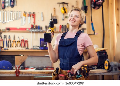 Young Smiling Handy Woman With Short Blond Hair Working With Screwdriver. 