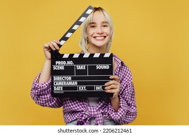 Young Smiling Happy Blonde Woman 20s She Wear Pink Tied Shirt White T-shirt Holding Classic Black Film Making Clapperboard Isolated On Plain Yellow Background Studio Portrait. People Lifestyle Concept