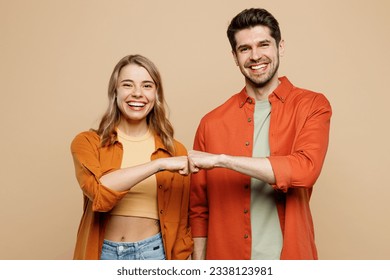 Young smiling happy buddies fun couple two friends family man woman wear casual clothes looking camera giving fist bumo together isolated on pastel plain light beige color background studio portrait - Shutterstock ID 2338123981