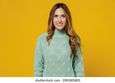 Young Smiling Happy Cheerful Fun Cool Blonde Satisfied European Caucasian Woman 30s Wearing Green Knitted Sweater Isolated On Plain Yellow Color Background Studio Portrait. People Lifestyle Concept