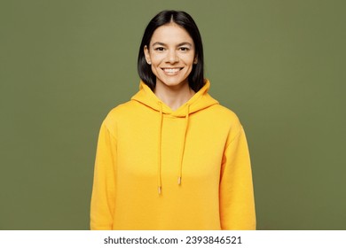 Young smiling happy cheerful satisfied cool positive Latin woman wearing yellow hoody casual clothes looking camera isolated on plain pastel green color background studio portrait. Lifestyle concept - Powered by Shutterstock