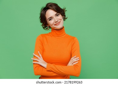 Young smiling happy confident woman 20s wear orange turtleneck hold hands crossed folded look camera isolated on plain pastel light green color background studio portrait. People lifestyle concept. - Shutterstock ID 2178199263