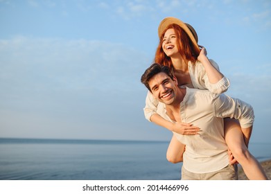 Young smiling happy couple two friends family man woman in white clothes boyfriend give piggyback ride to joyful, girlfriend sit on back at sunrise over sea beach ocean outdoor seaside in summer day - Powered by Shutterstock