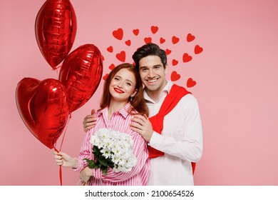 Young Smiling Happy Couple Two Friends Woman Man Wear Shirt Hold Red Bunch Of Balloons Bouquet Of Flowers Isolated On Plain Pink Background Studio Portrait. Valentine's Day Birthday Party Concept.