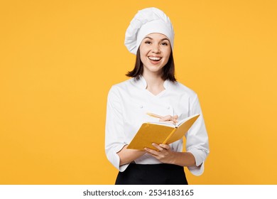 Young smiling happy fun chef cook baker woman she wear white shirt black apron uniform toque chefs hat hold in hand book reading recipe isolated on plain yellow background studio. Cooking food concept - Powered by Shutterstock