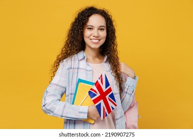 Young Smiling Happy Fun Cool Black Teen Girl Student She Wearing Casual Clothes Backpack Bag Hold Books British Flag Isolated On Plain Yellow Color Background. High School University College Concept