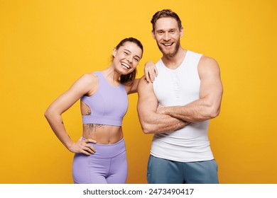 Young smiling happy fun fitness trainer instructor sporty two man woman wears blue clothes spend time in home gym put hand on shoulder isolated on plain yellow background. Workout sport fit concept - Powered by Shutterstock