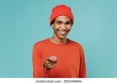 Young Smiling Happy Leader Cheerful Fun African American Man In Red Shirt Hat Point Index Finger Camera On You Isolated On Plain Pastel Light Blue Background Studio Portrait. People Lifestyle Concept