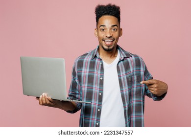 Young smiling happy man of African American ethnicity 20s he wear blue shirt hold use work point finger on laptop pc computer isolated on plain pastel light pink background People lifestyle concept - Shutterstock ID 2231347557