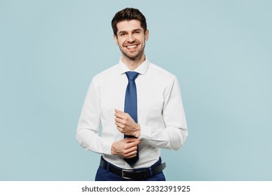 Young smiling happy successful employee business man corporate lawyer wears classic formal shirt tie work in office posing look camera isolated on plain pastel light blue background studio portrait