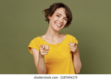 Young smiling happy woman she 20s wear yellow t-shirt pointing index fingers camera on you motivating encourage isolated on plain olive green khaki background studio portrait. People lifestyle concept - Shutterstock ID 2187696175