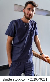 Young Smiling Young Male Doctor Dentist In Dark Blue Uniform Standing In Hallway