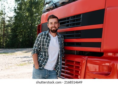 Young Smiling Male Truck Driver Beside His Red Cargo Truck Is Happy About His Work