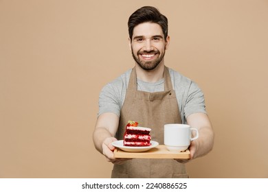 Young smiling man barista barman employee wear brown apron work in coffee shop hold give cake tea sweet dessert breakfast isolated on plain pastel light beige background Small business startup concept - Powered by Shutterstock