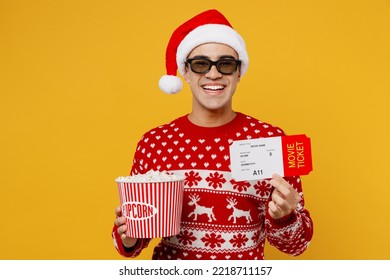 Young Smiling Man In Red Knitted Christmas Sweater Santa Hat Posing 3d Glasses Watch Movie Film Hold Ticket Bucket Of Popcorn In Cinema Isolated On Plain Yellow Background Happy New Year 2023 Concept