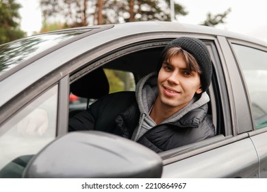 Young Smiling Man Student Sitting In His New Car. Rent Car Or Buying First Car Concept.