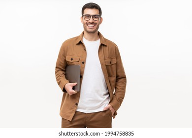 Young smiling modern man or male teacher holding laptop, isolated on gray background