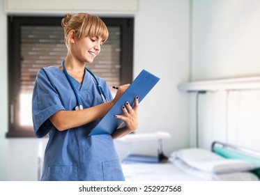 Young smiling nurse writing on a clipboard