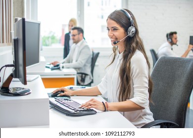 Young smiling operator woman agent with headsets working in call center. - Powered by Shutterstock