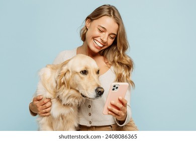 Young smiling owner woman with her best friend retriever wear casual clothes use mobile cell phone hug embrace dog isolated on plain pastel light blue background studio. Take care about pet concept - Powered by Shutterstock