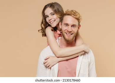 Young Smiling Parent Man Have Fun With Child Teen Girl In Casual Pastel Clothes Daddy Little Kid Daughter Look Camera Hug Stand Behind Isolated On Beige Background. Father's Day Love Family Concept