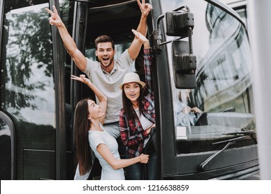 Young Smiling People Traveling on Tourist Bus. Group of Happy Friends Standing Together in Doors of Tour Bus. Traveling, Tourism and People Concept. Happy Travelers on Trip. Summer Vacation