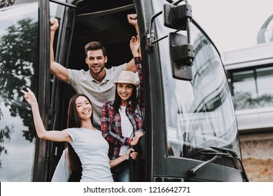 Young Smiling People Traveling on Tourist Bus. Group of Happy Friends Standing Together in Doors of Tour Bus. Traveling, Tourism and People Concept. Happy Travelers on Trip. Summer Vacation