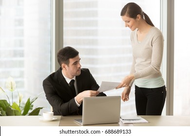 Young Smiling Personal Assistant Giving Document To Boss In His Office, Female Accountant Reporting Great Work To Ceo, Junior Manager Showing To Executive Increased Financials, Project Stats On Paper