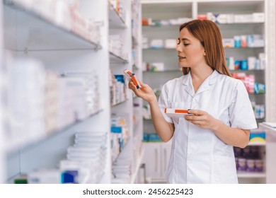 Young  smiling pharmacist searching for medication in the pharmacy. - Powered by Shutterstock