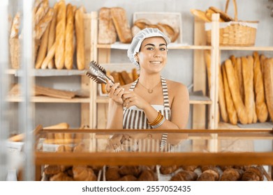 Young smiling saleswoman holding a service clip while ready to assist customers - Powered by Shutterstock