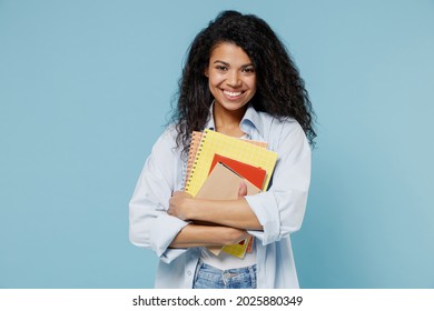 Young Smiling Smart Nerd African American Girl Teen Student Wear Denim Clothes Holding Books Prepare For Exam Notebook Isolated On Blue Background Education In High School University College Concept