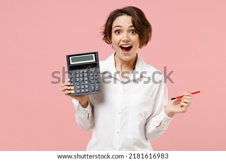 Young smiling successful employee business secretary woman corporate lawyer in classic formal white shirt work in office hold in hands calculator isolated on pastel pink background studio portrait.