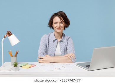 Young smiling successful secretary employee business woman in casual shirt sit work at white office desk with pc laptop isolated on pastel blue background studio portrait. Achievement career concept - Powered by Shutterstock