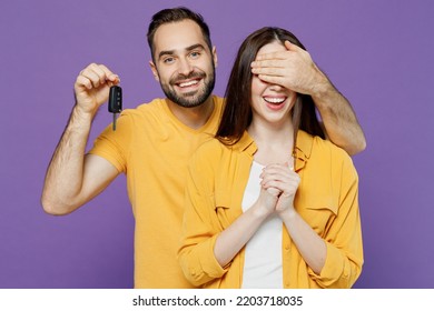 Young Smiling Surprised Happy Fun Couple Two Friends Family Man Woman Together Wear Yellow Clothes Cover Eyes Hold Car Key Fob Keyless System Gift Isolated On Plain Violet Background Studio Portrait