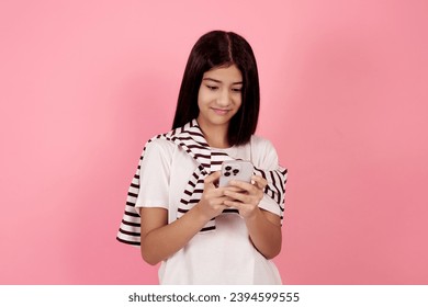 Young smiling teenage girl with bag on pink background in studio. - Shutterstock ID 2394599555