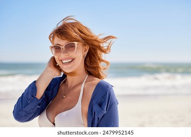 Young smiling woman in bikini with casual shirt at tropical beach looking at camera. Portrait of beautiful girl wearing fashion specs with ocean in background. Happy woman with sunglasses, copy space. - Powered by Shutterstock