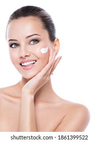 Young smiling woman with cosmetic  cream on a clean fresh face