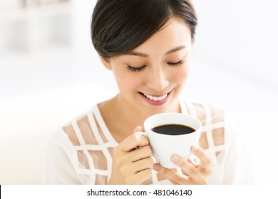 young smiling woman drinking coffee in the morning